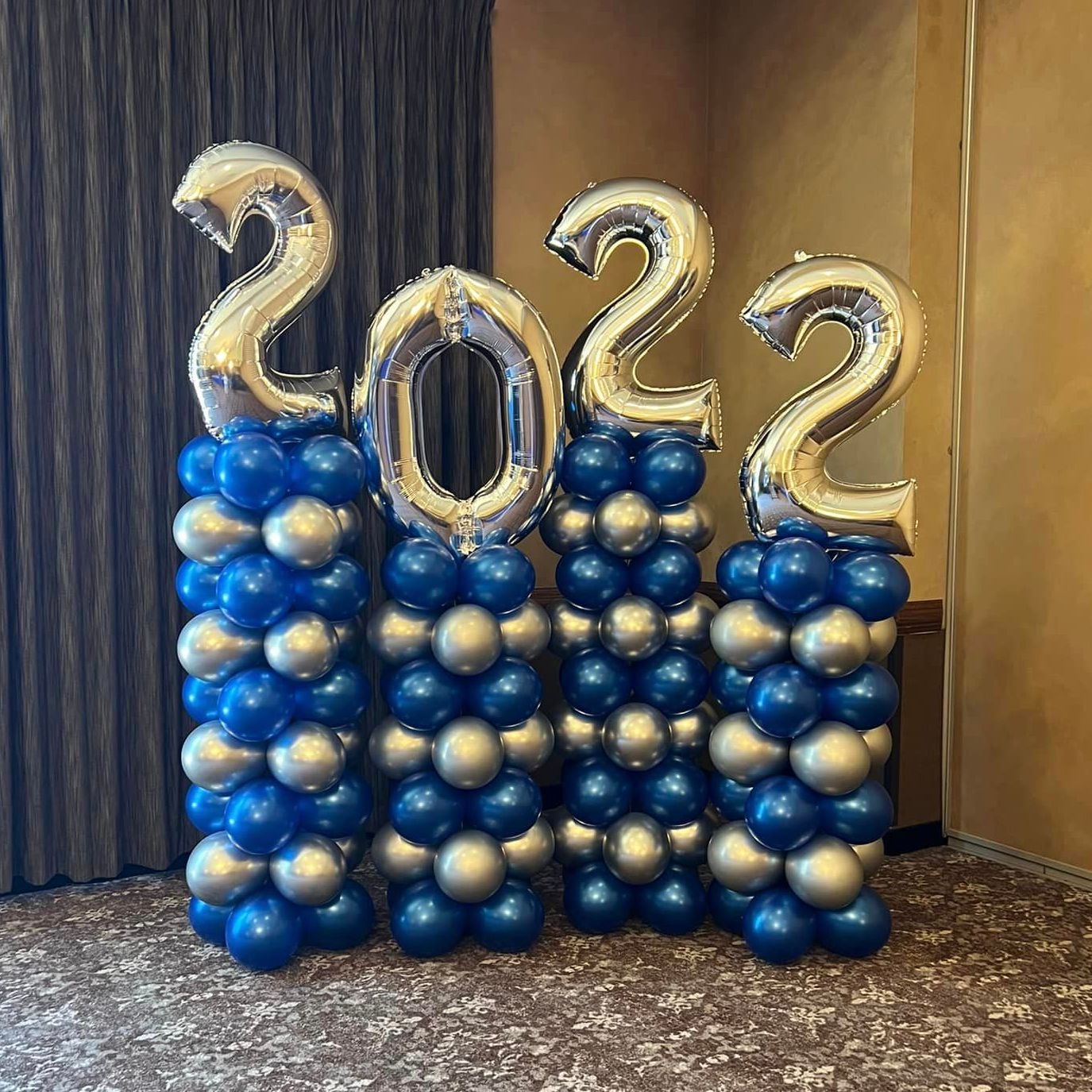 Classic balloon columns with a color-stacked pattern, alternating heights to add shape and dimension. Featuring chrome blue and chrome silver balloons, these columns create a striking focal point at Avalon Manor in Northwest Indiana, perfect for enhancing any space.