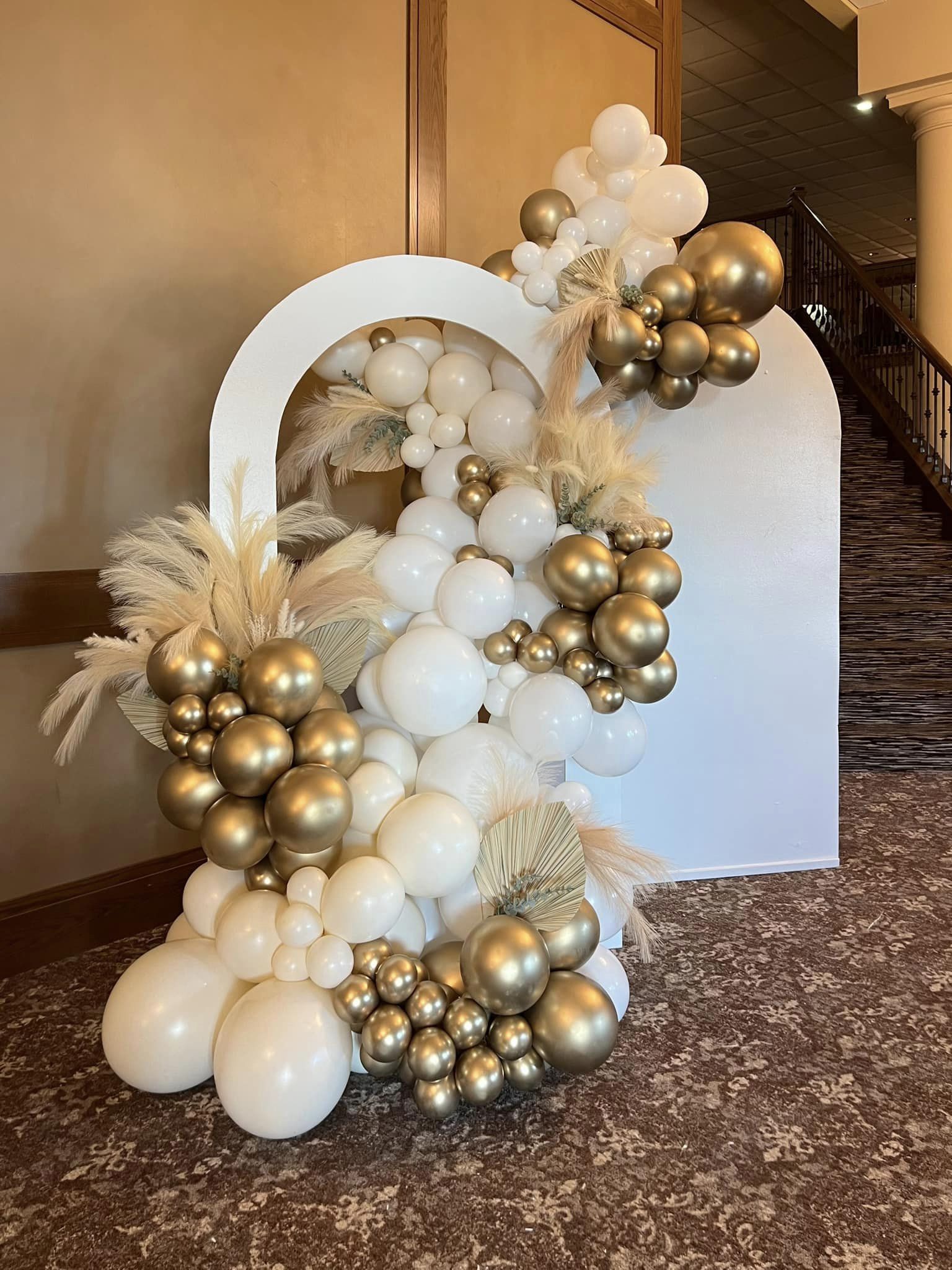 Deluxe  organic grand balloon garland with a walkthrough arch and second wall, featuring neutral tones in shades of white with gold and pampas accents at Avalon Manor in Merrillville, Indiana. Perfect for elegant events and upscale celebrations.