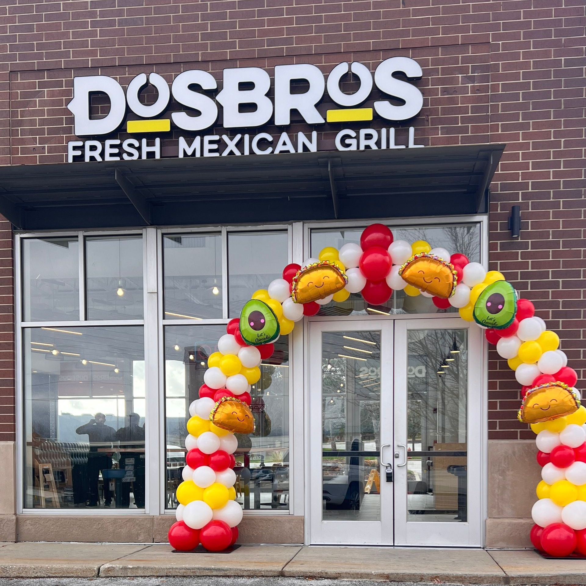 Classic red and yellow balloon arch for Dos Bros Grand Opening in Lake County, celebrating small business success.