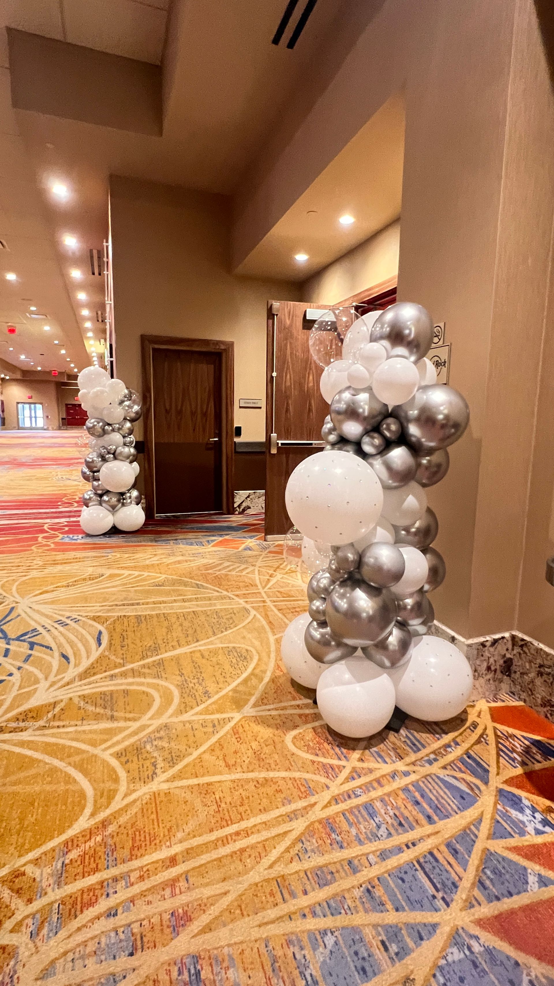 simple, clean, white and chrome silver free standing garland entry way piece for a Corporate event 