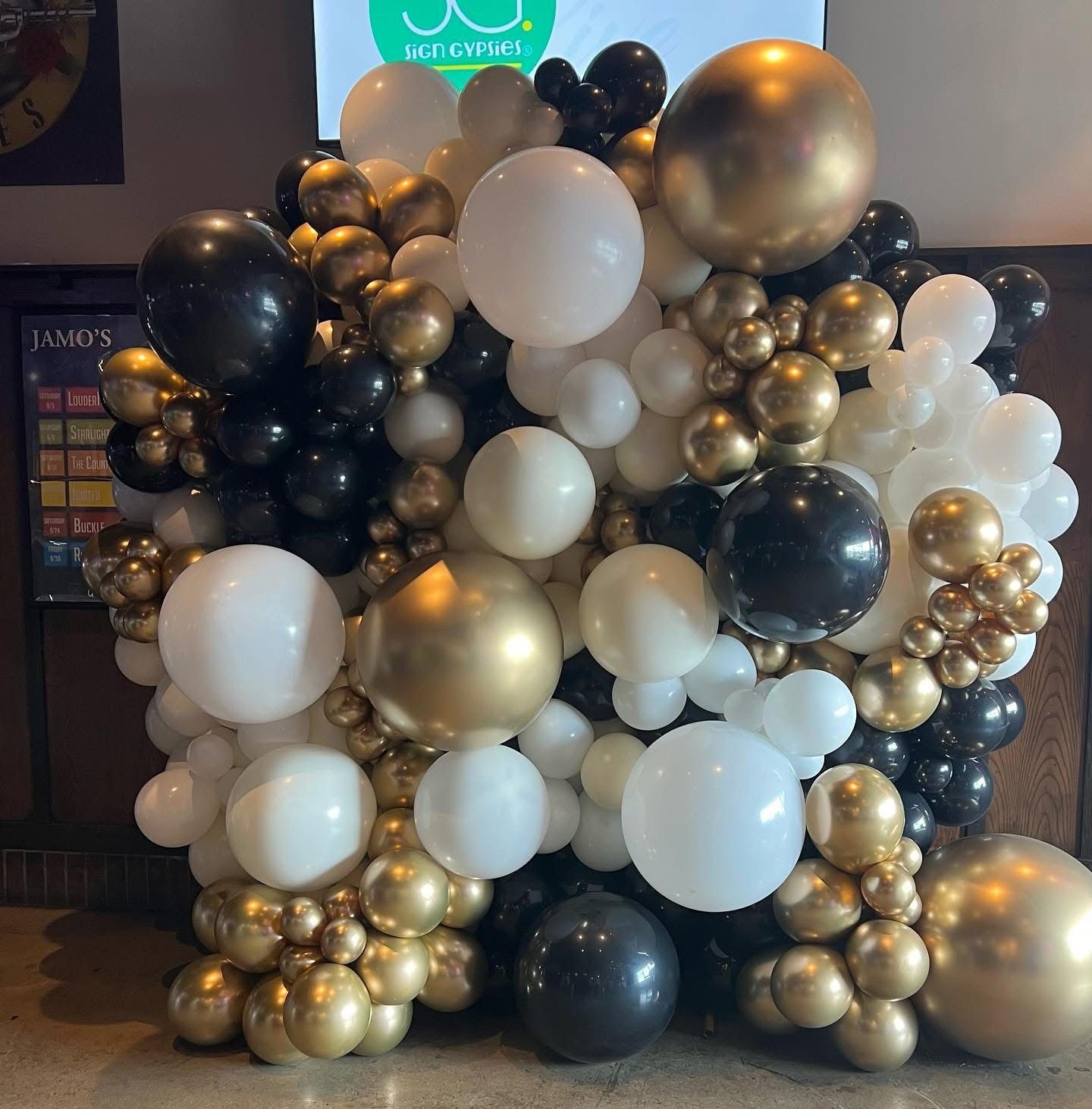 white black and gold organic balloon wall for a fundraiser 