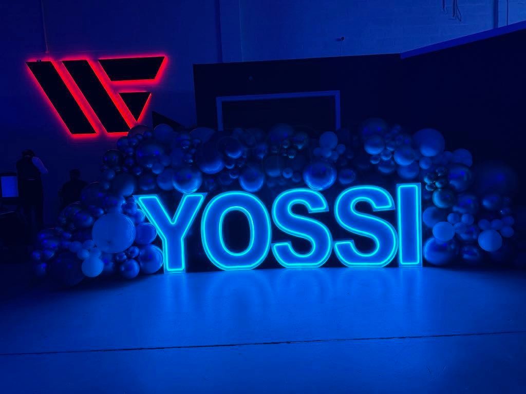 Yossi LED marquee display for a corporate event, featuring a custom balloon garland and an LED company logo, ideal for brand activations, company celebrations, and professional event decor.
