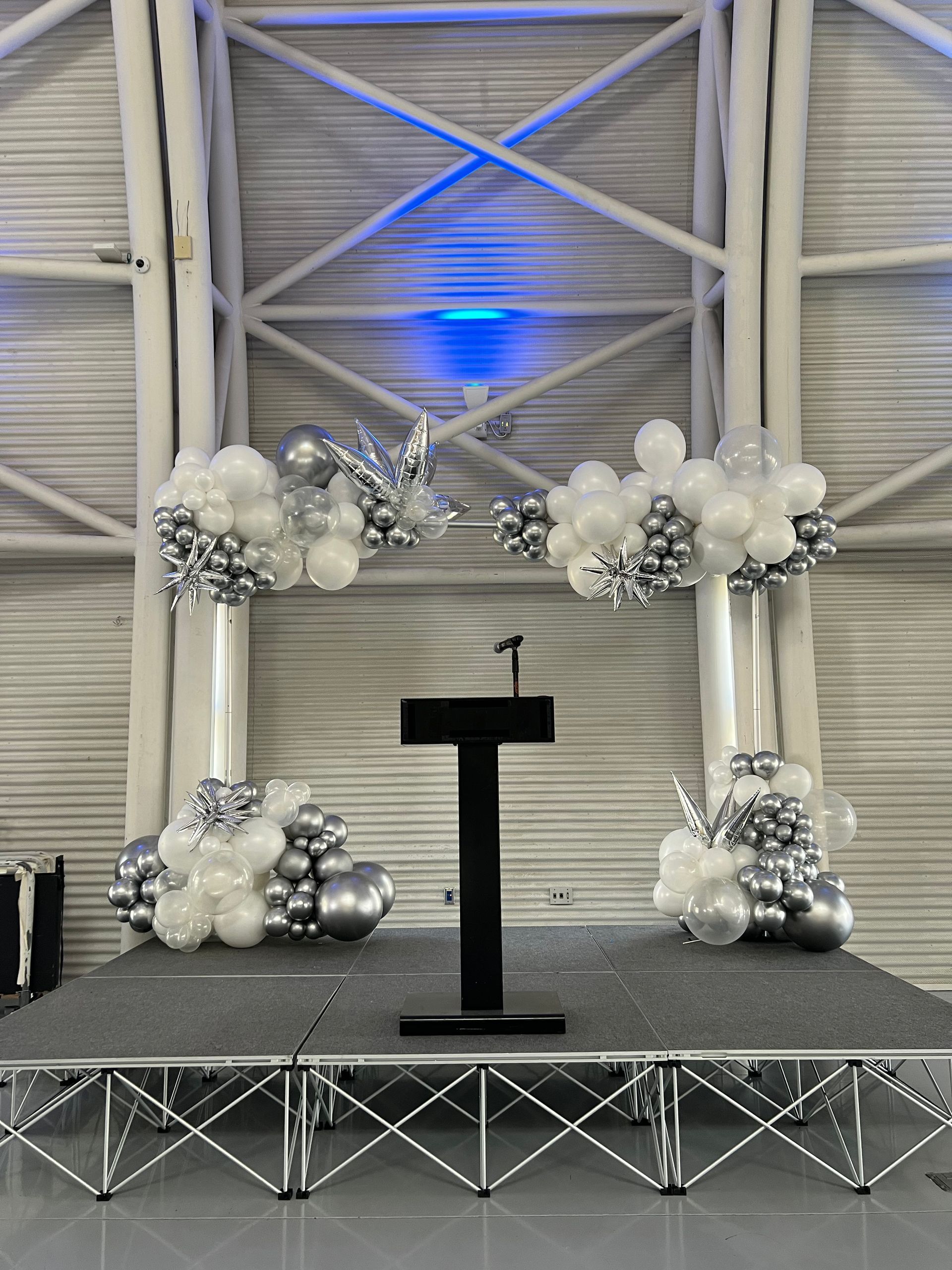 skyscraper balloon arch frames a speaker at a company meeting in northwest Indiana 