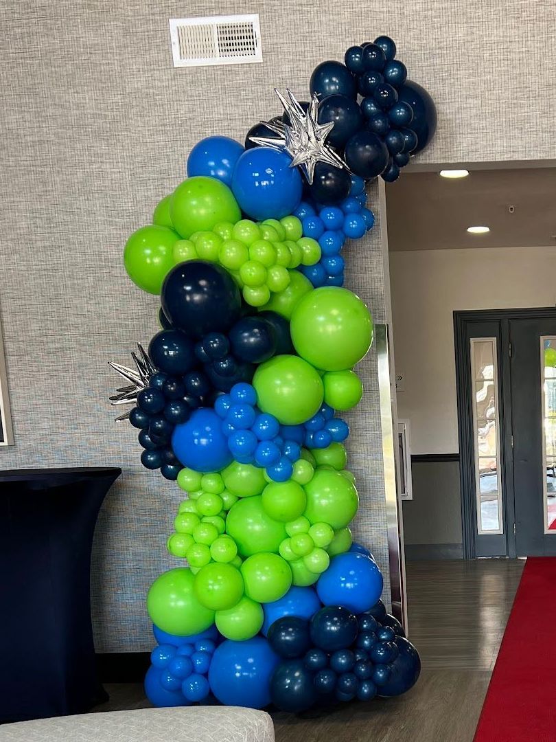 Grand luxury organic balloon column in vibrant lime green, party blue, and navy blue, creating a statement-making entrance piece. Perfect for events that require jaw-dropping decor, designed to captivate and impress guests with its bold, eye-catching design.