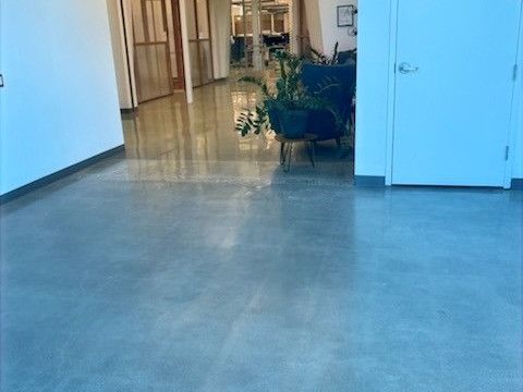 A hallway with a concrete floor and a white door