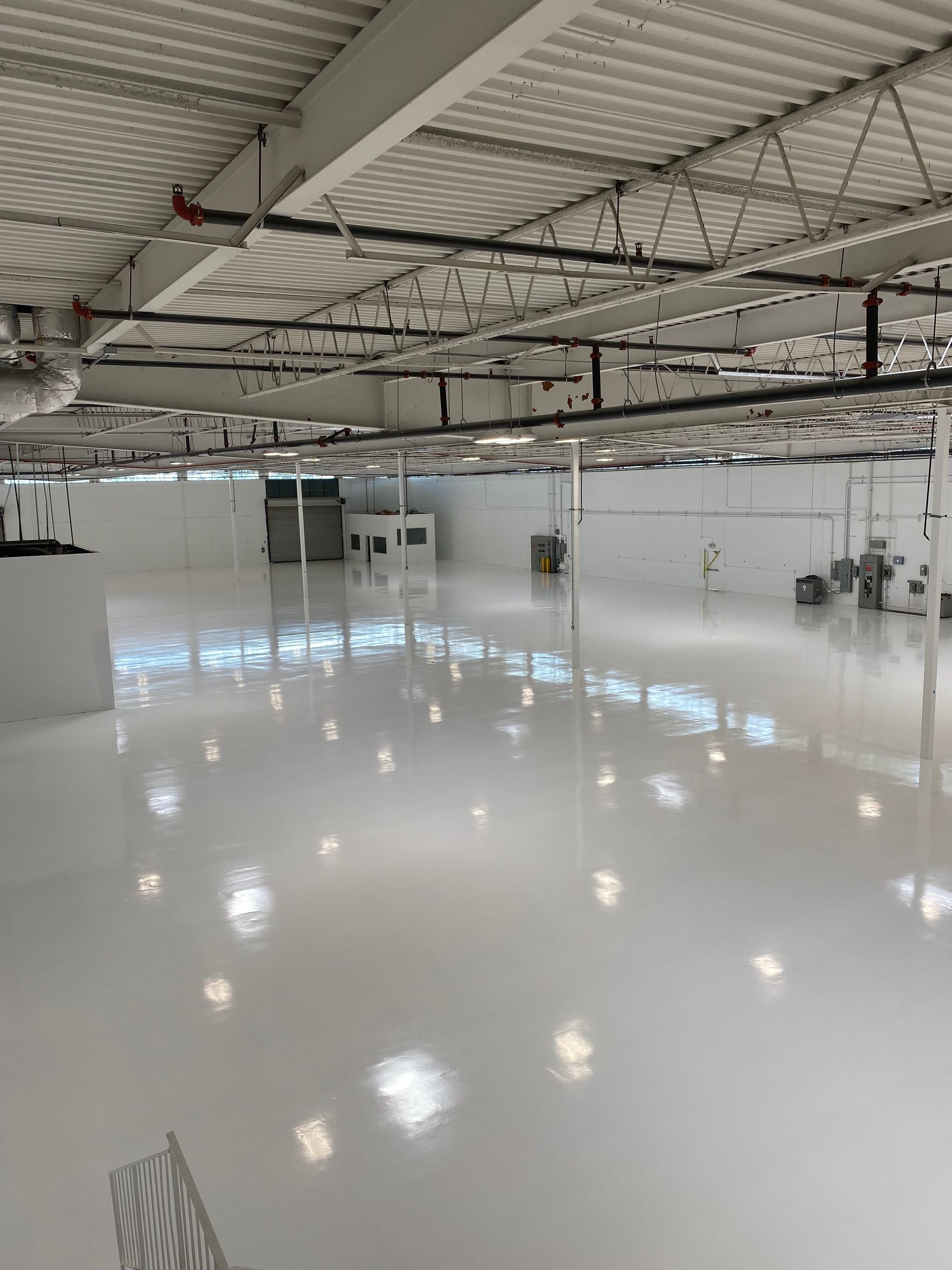 A large warehouse with a white floor and ceiling