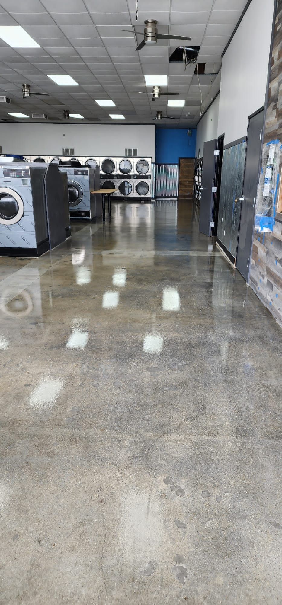 A laundromat with a lot of washers and dryers in it.