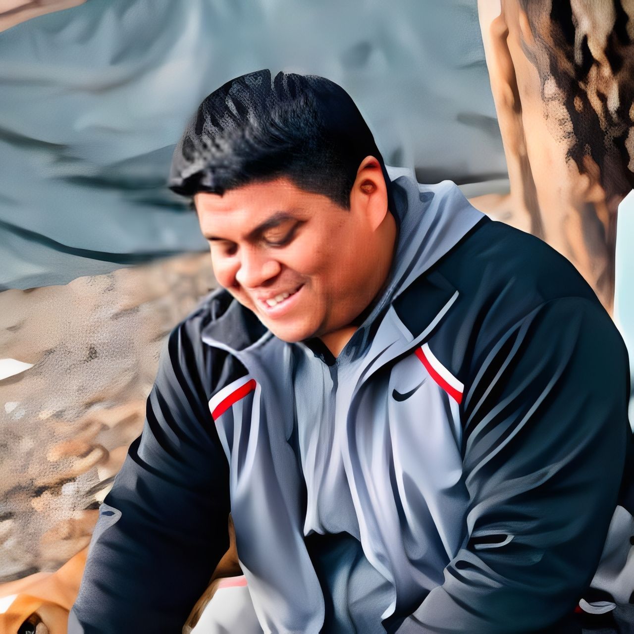 A man in a nike jacket is sitting on the ground with a dog.