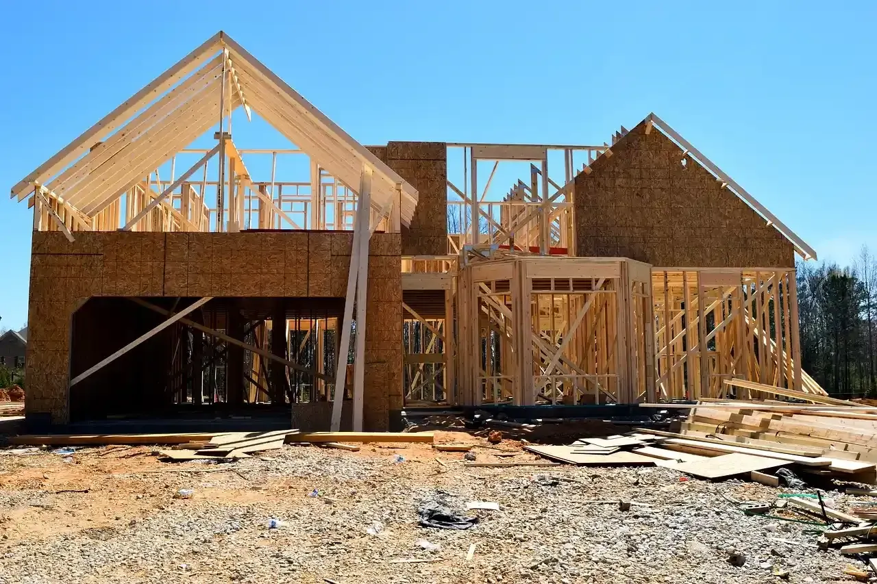 Partially framed house under construction with exposed wood framing and a gabled roof