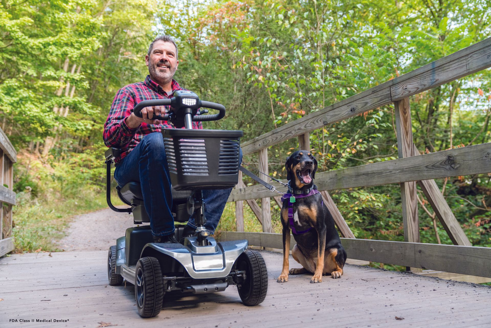 A man is riding a mobility scooter next to a dog.