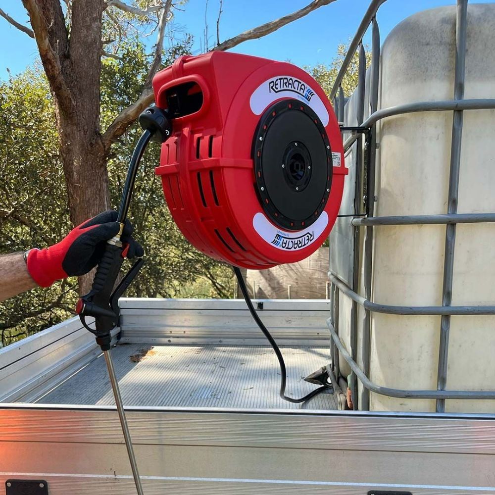 A Red Hose Reel Is Attached to The Back of A Truck — Wades Distributors In Cairns, QLD