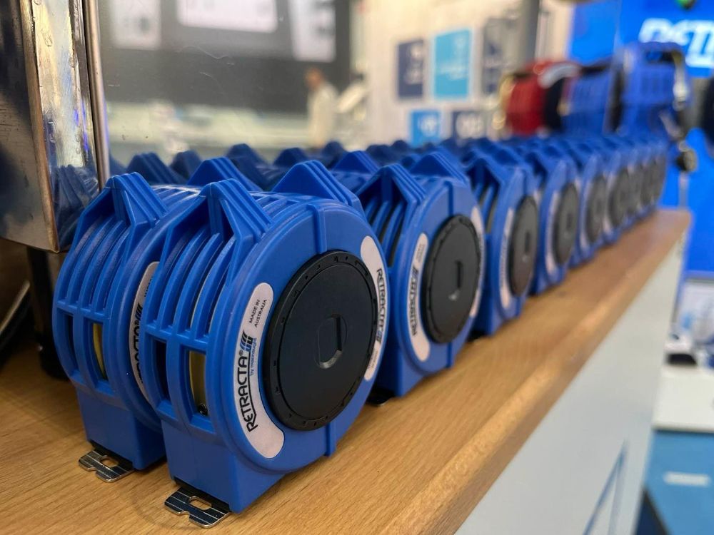 A Row of Blue Tape Measures Are Lined up On a Wooden Shelf — Wades Distributors In Garbutt, QLD