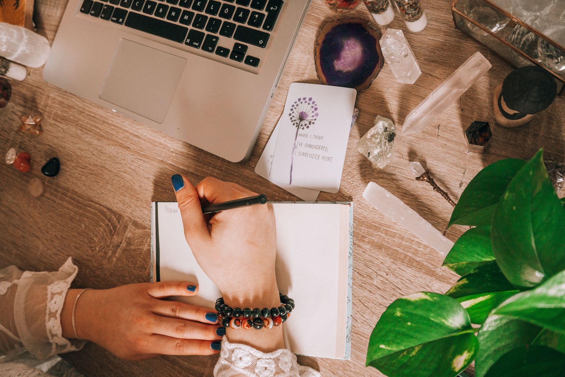 Woman meditating and journaling with crystals in a calm home setting