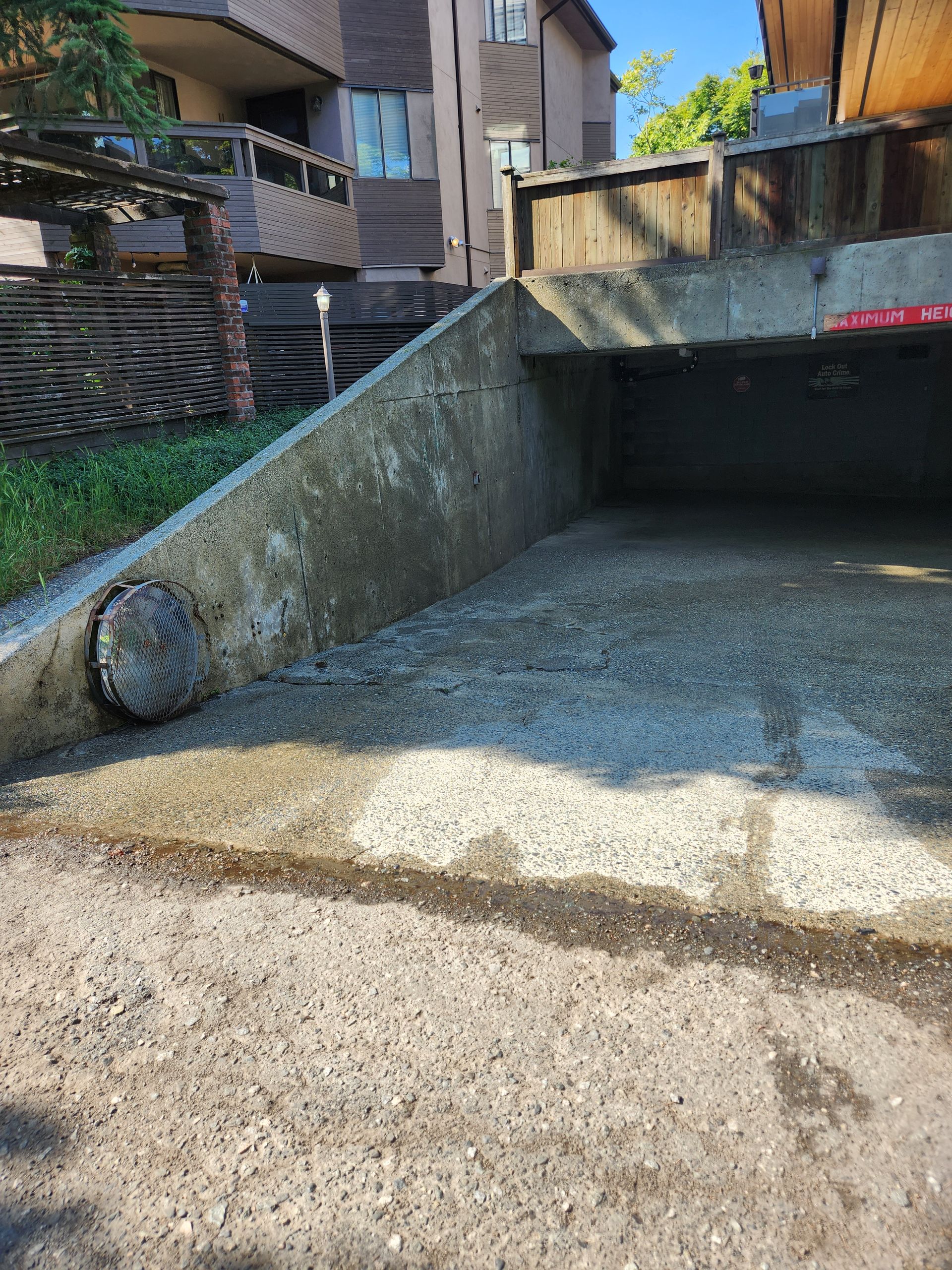 A concrete ramp leading to a parking garage with a building in the background.