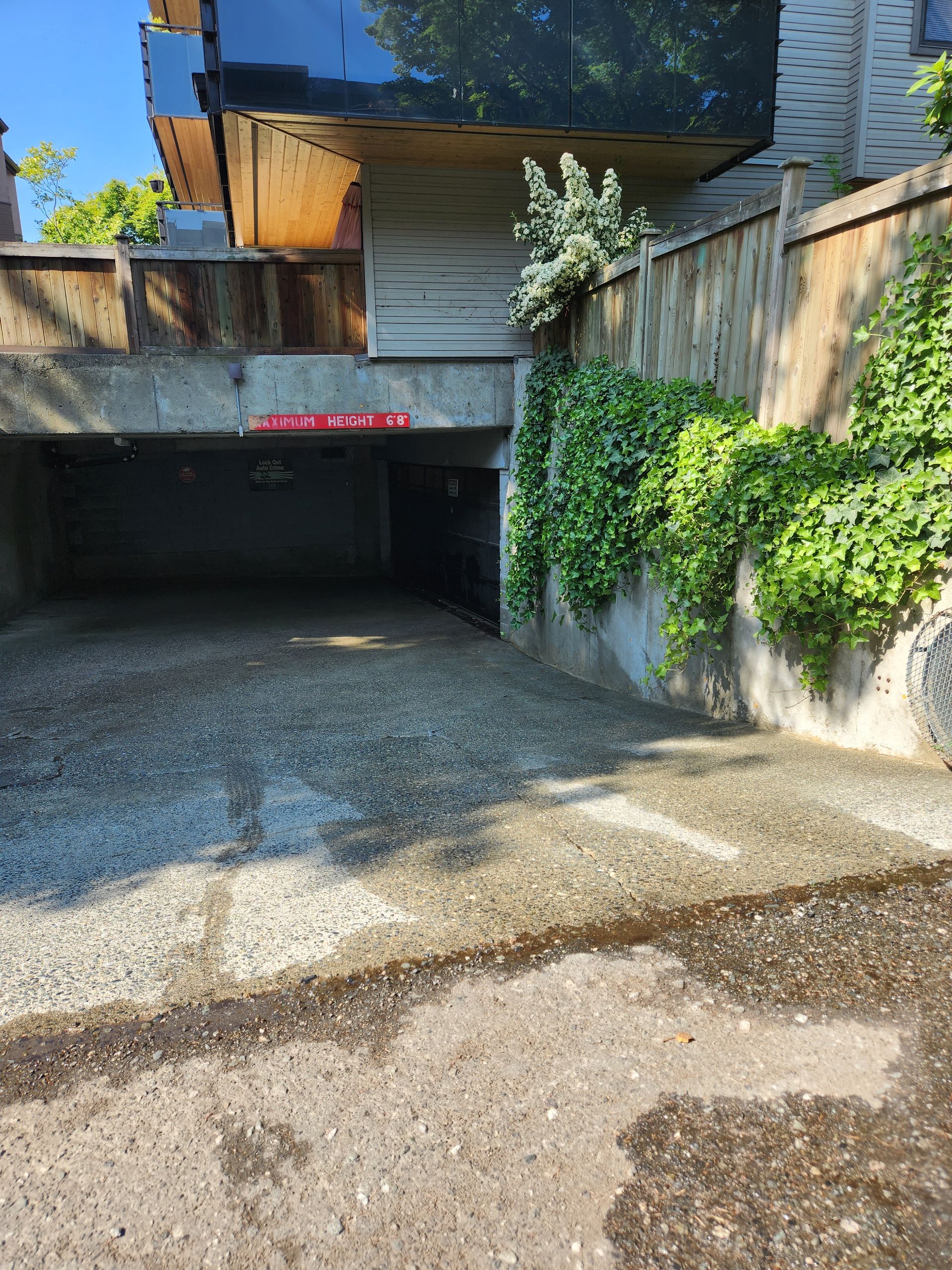 A parking garage underneath a building with a red sign that says no parking.