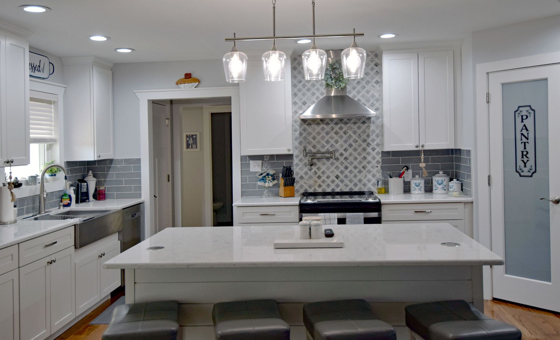 A kitchen with white cabinets and a large island in the middle.