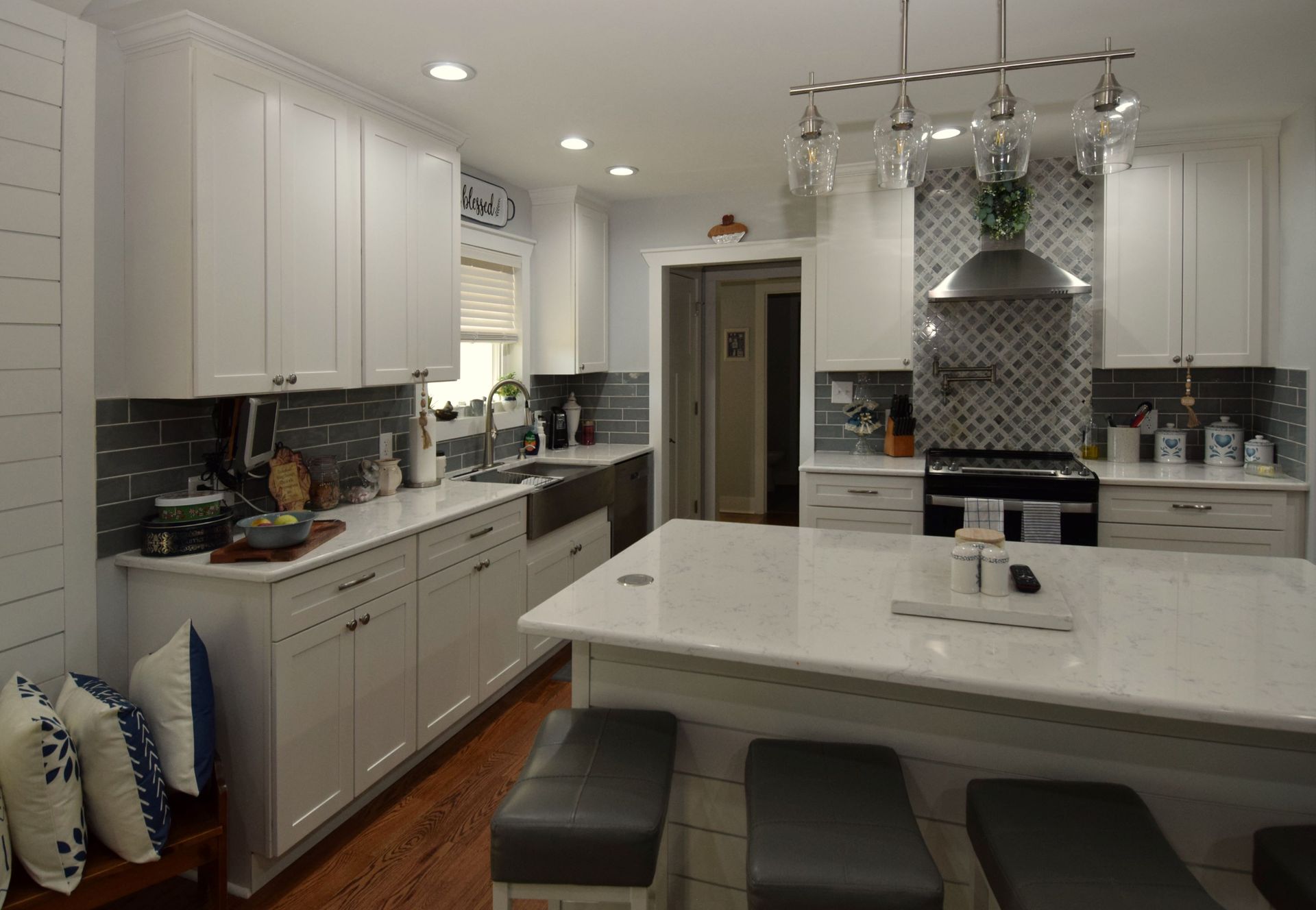 A kitchen with white cabinets and a large island