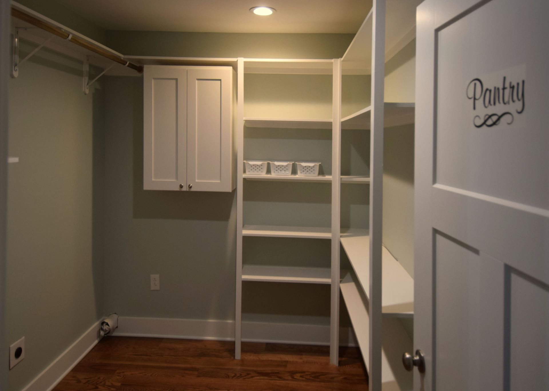 A walk in pantry with shelves and a door that says pantry