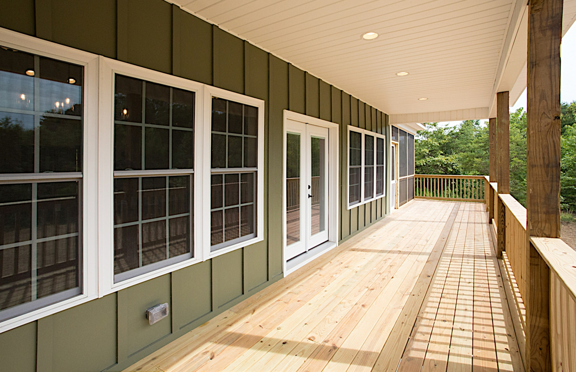 A large porch with lots of windows and doors