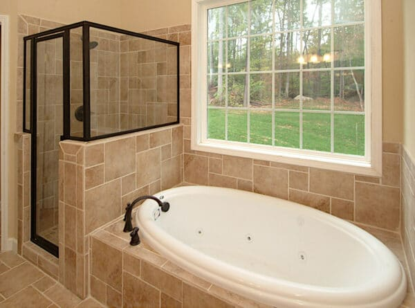 A bathroom with a tub , shower and window