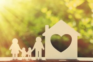 A paper cut out of a family and a house with a heart in the middle.