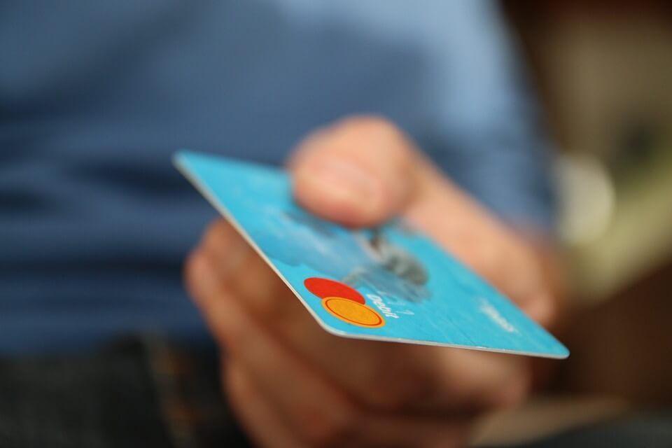 A person is holding a credit card in their hand.