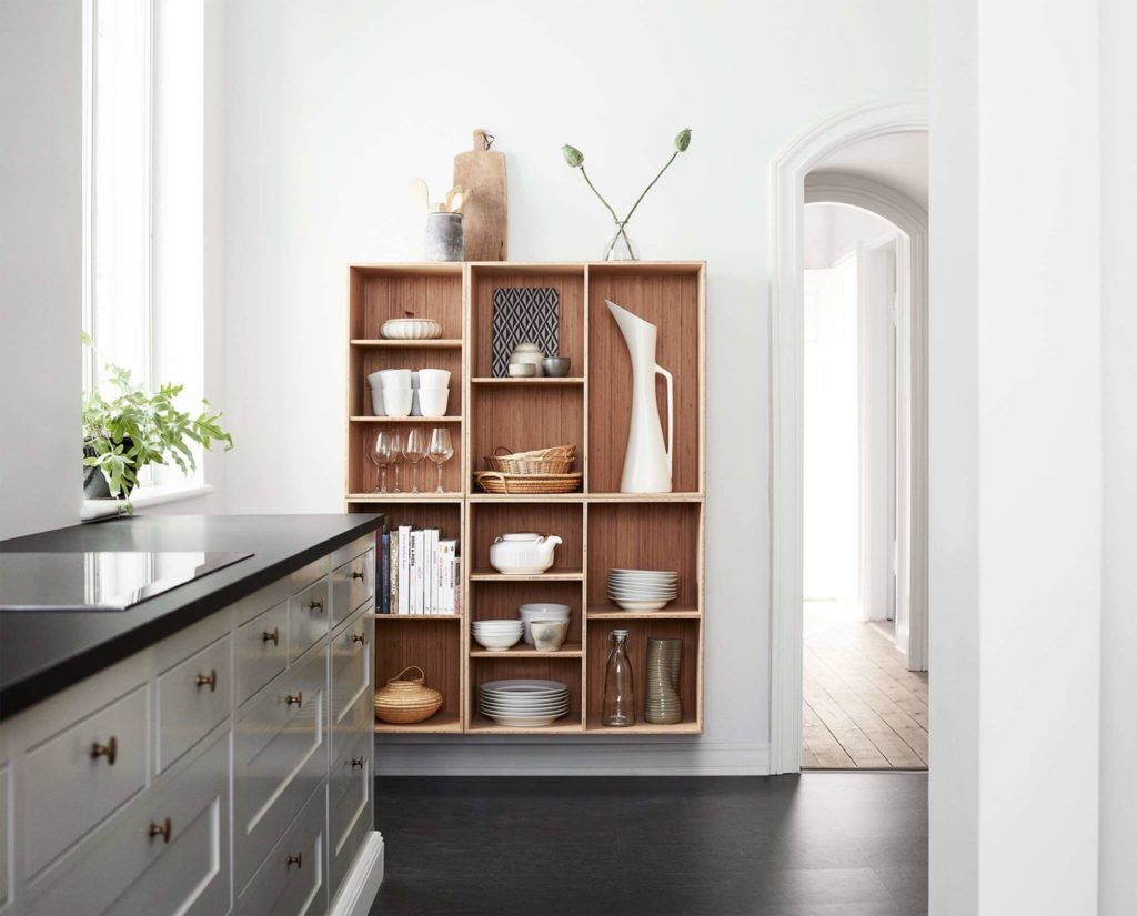 A kitchen with white cabinets and wooden shelves