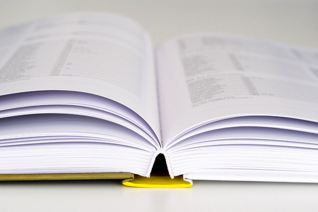 A close up of an open book with a yellow bookmark
