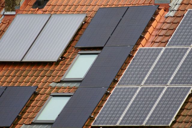 Solar panels installed on a red-tiled roof with skylights.
