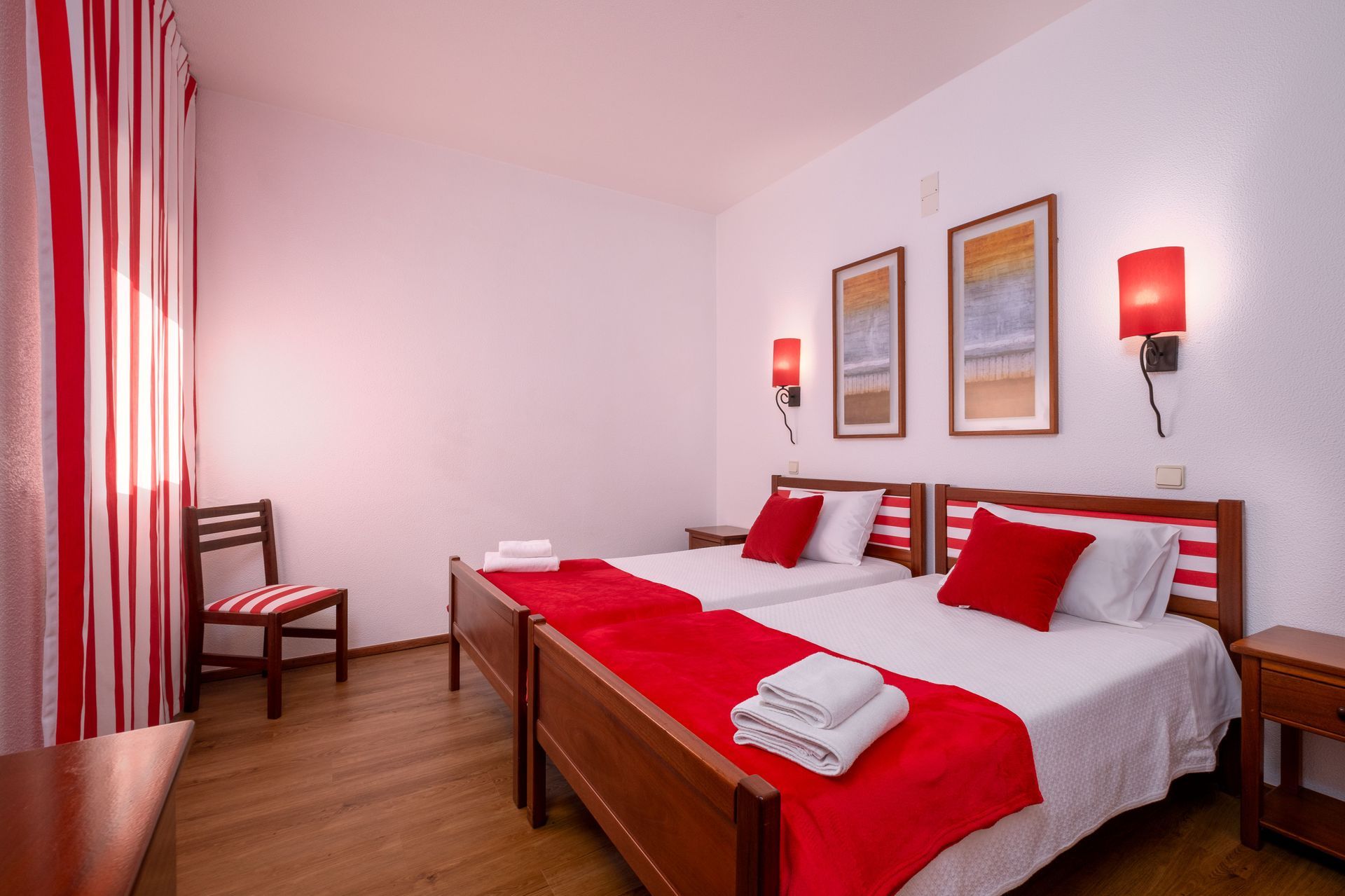 Um quarto de hotel com duas camas e uma cadeira