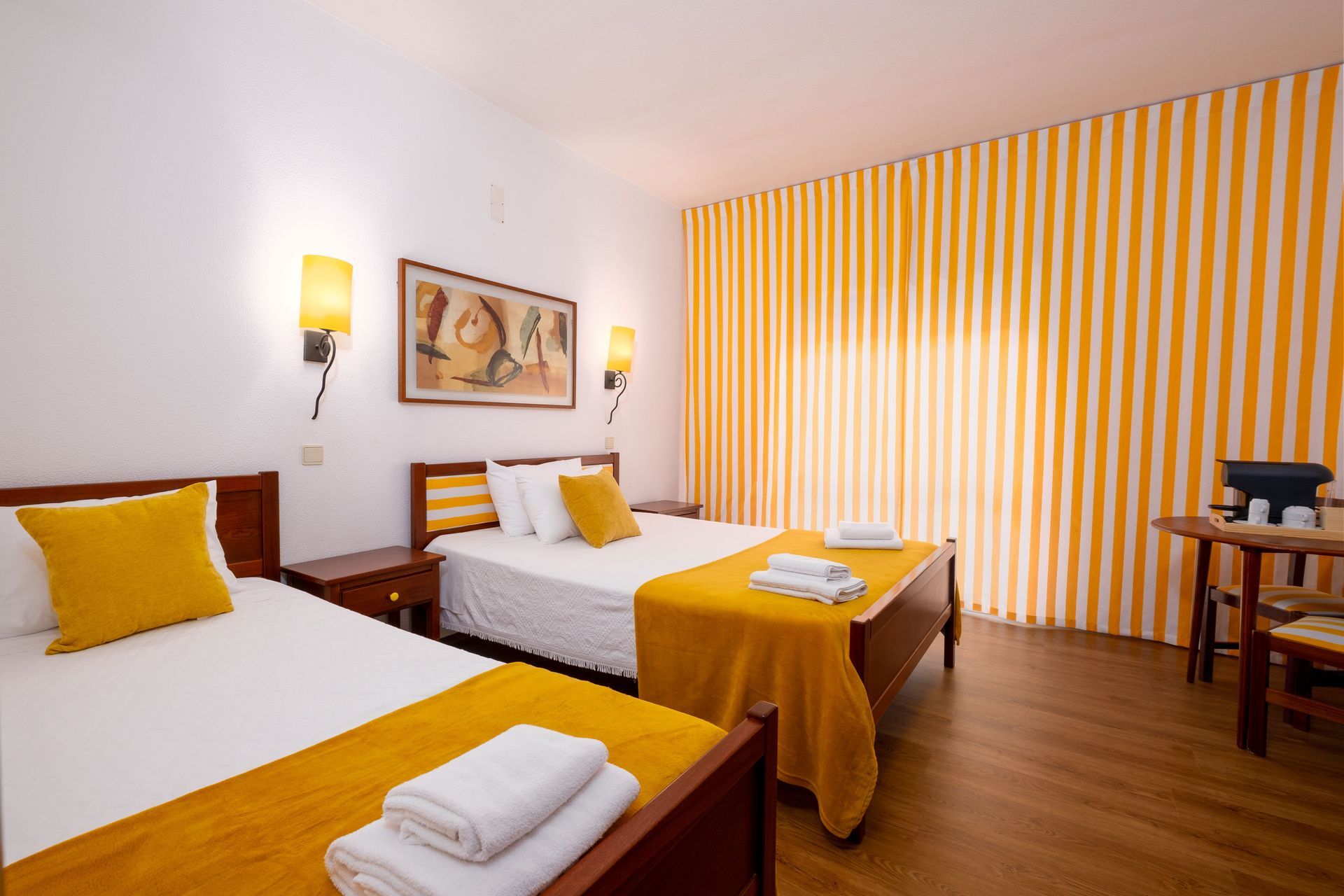 Um quarto de hotel com duas camas e cortinas listradas