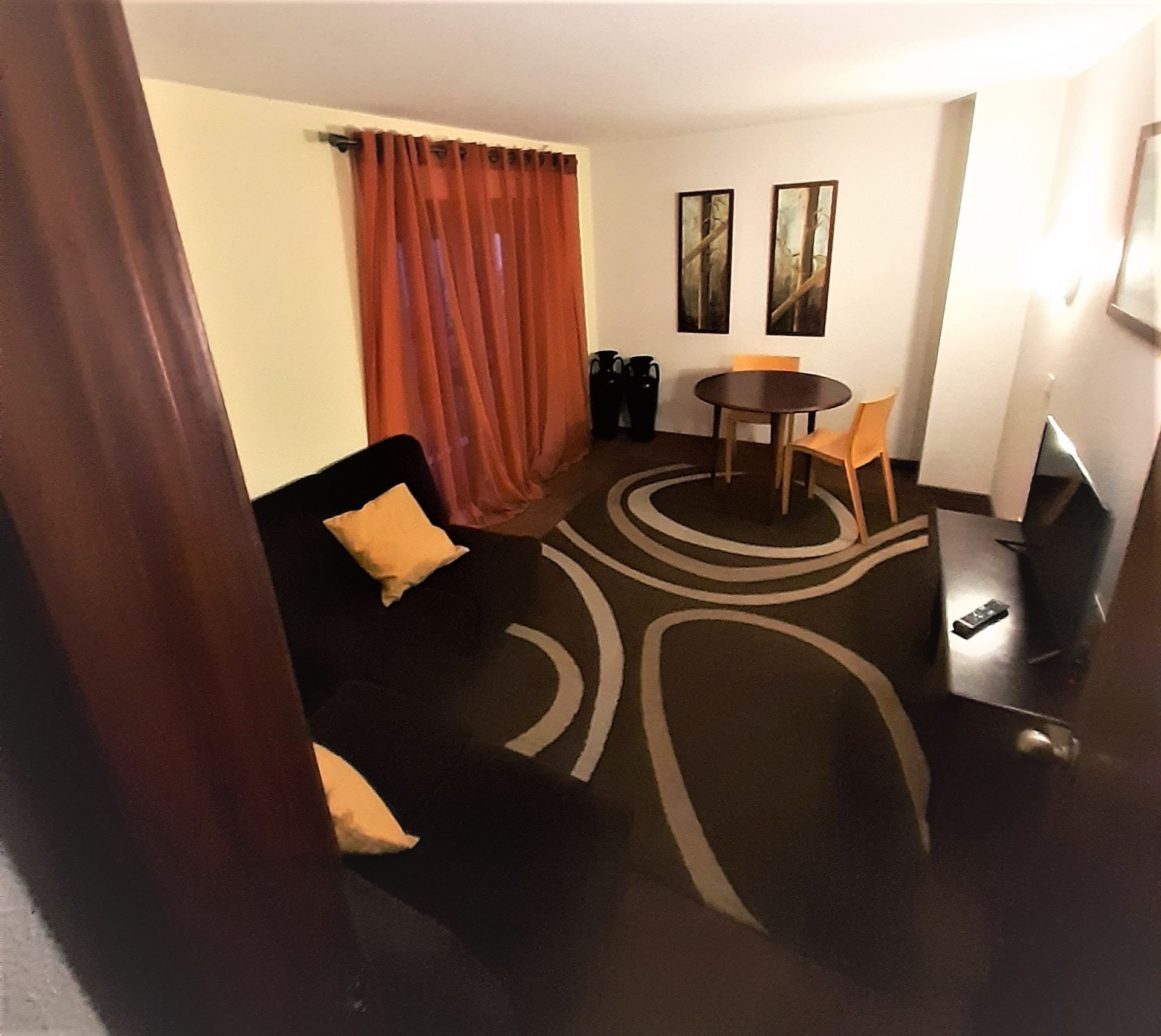 Uma sala de estar com um sofá, uma mesa e cadeiras