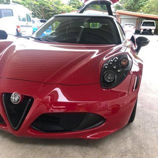 A car ceramic coating service done on the Sunshine Coast A red sports car is parked in a parking lot.