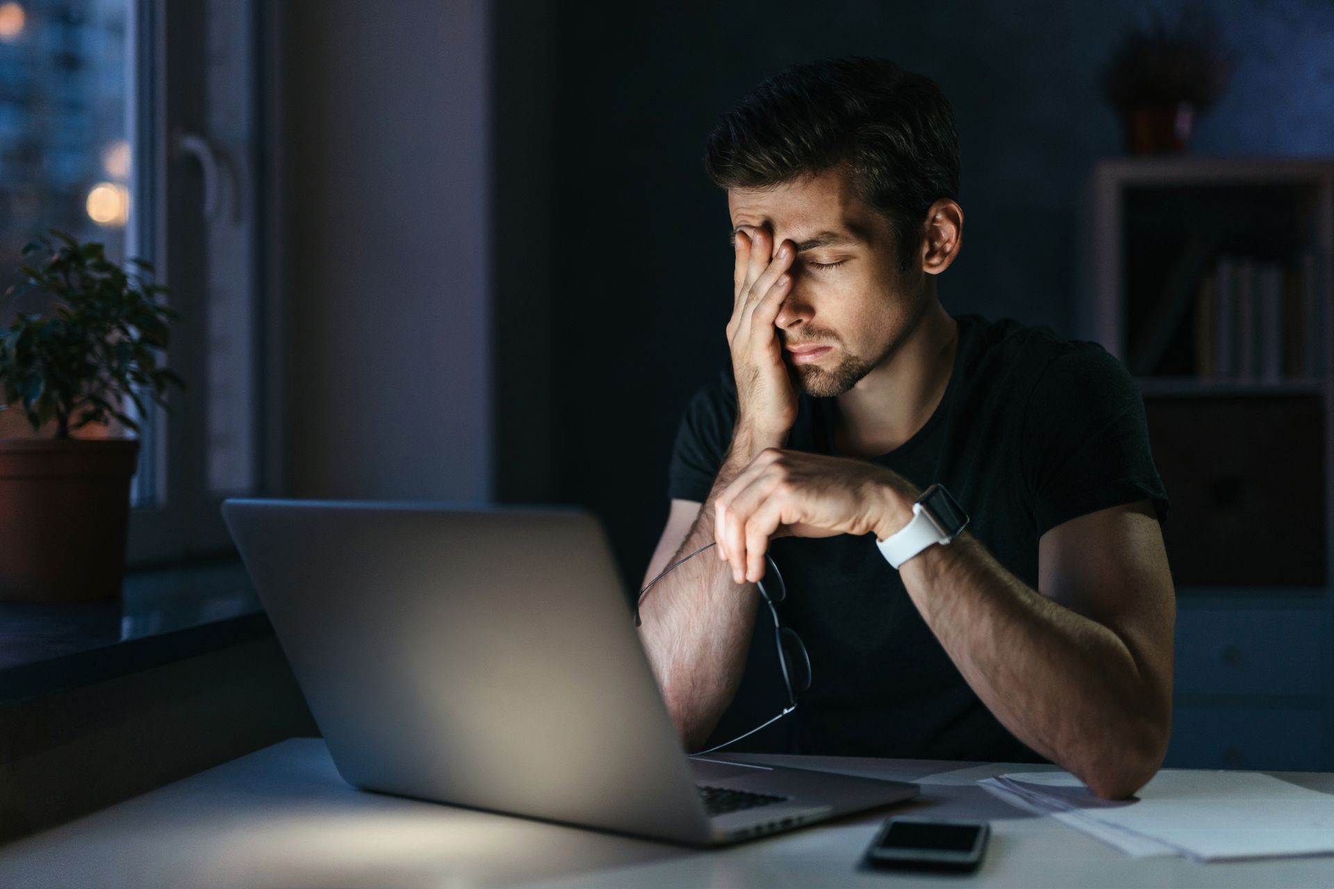 Young businessman has a headache working on laptop. Stressed and tired.