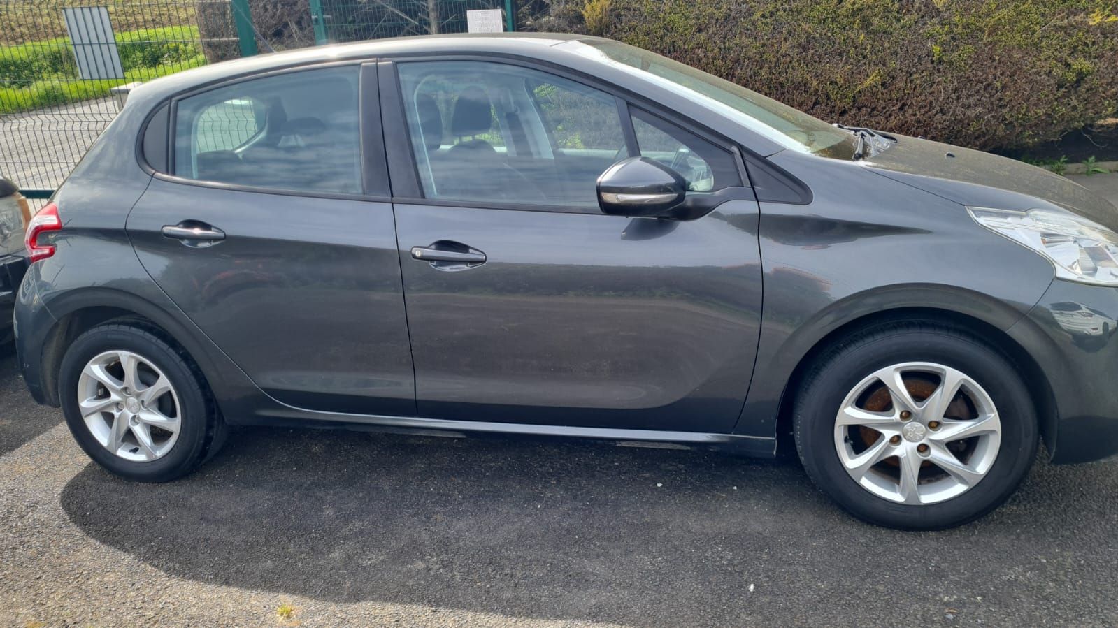 A dark gray five-door hatchback car parked on an asphalt surface.