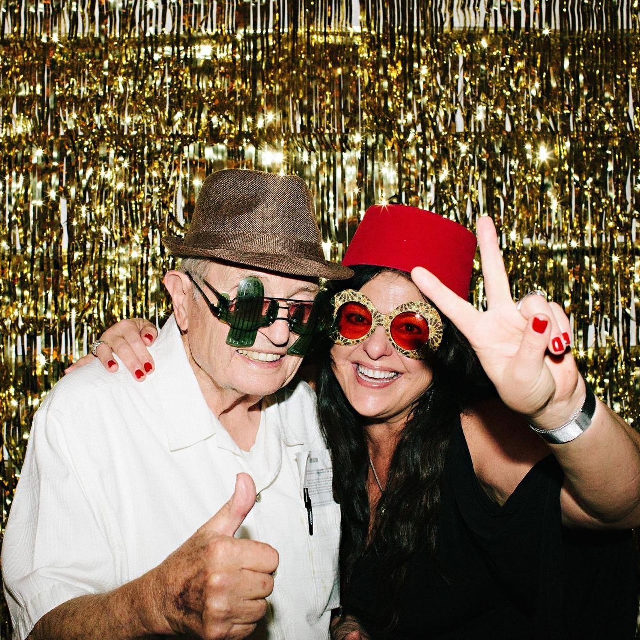 A man and a woman are posing for a picture and the woman is wearing a red hat - Linda and her father
