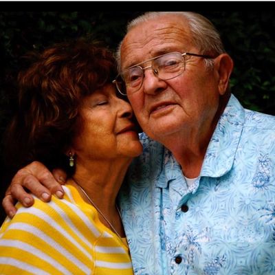 African-American senior couple smiling and sitting on a couch
