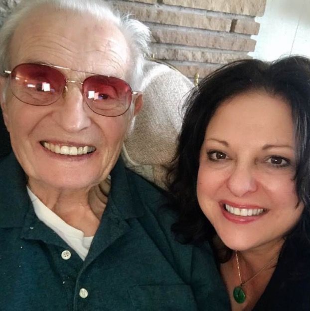 A man and a woman are posing for a picture and smiling - Linda and her father