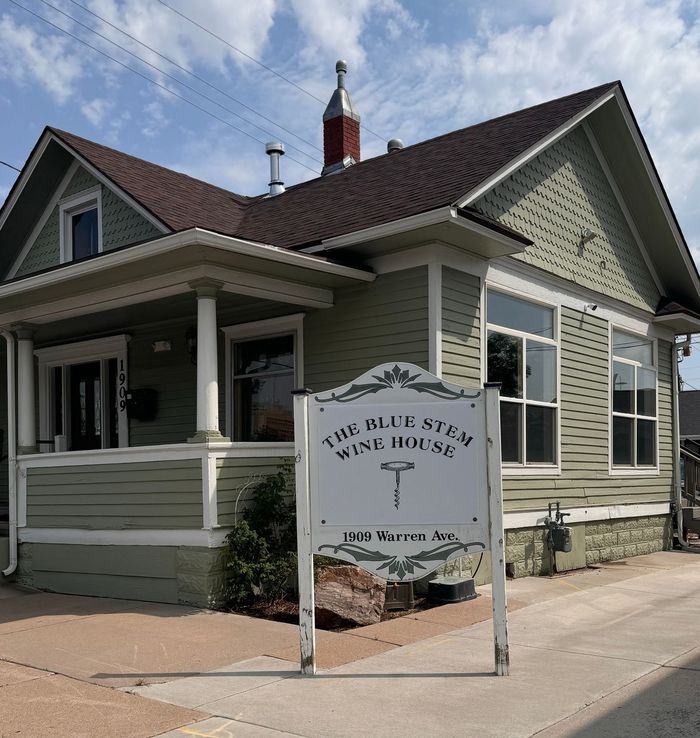 A house with a sign that says the blue stem wine house