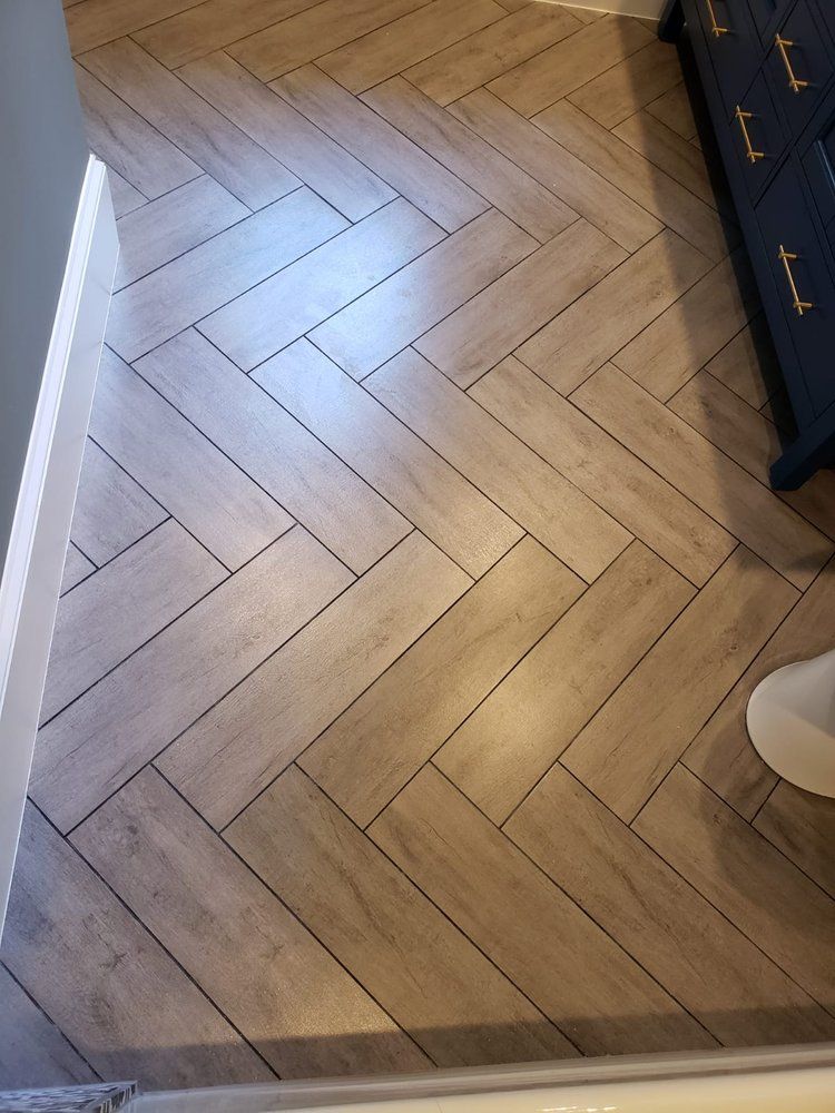 Herringbone pattern floor tiles in neutral tones.