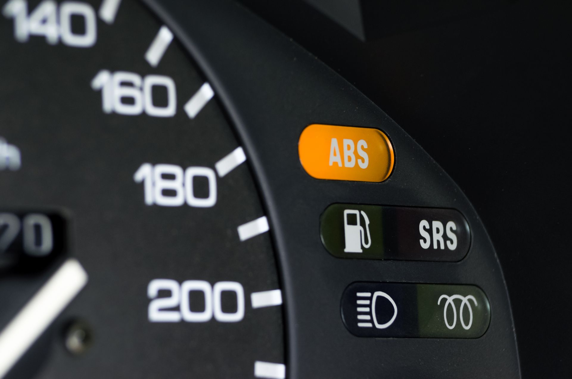 Car dashboard gauge with illuminated ABS warning light and other indicator icons