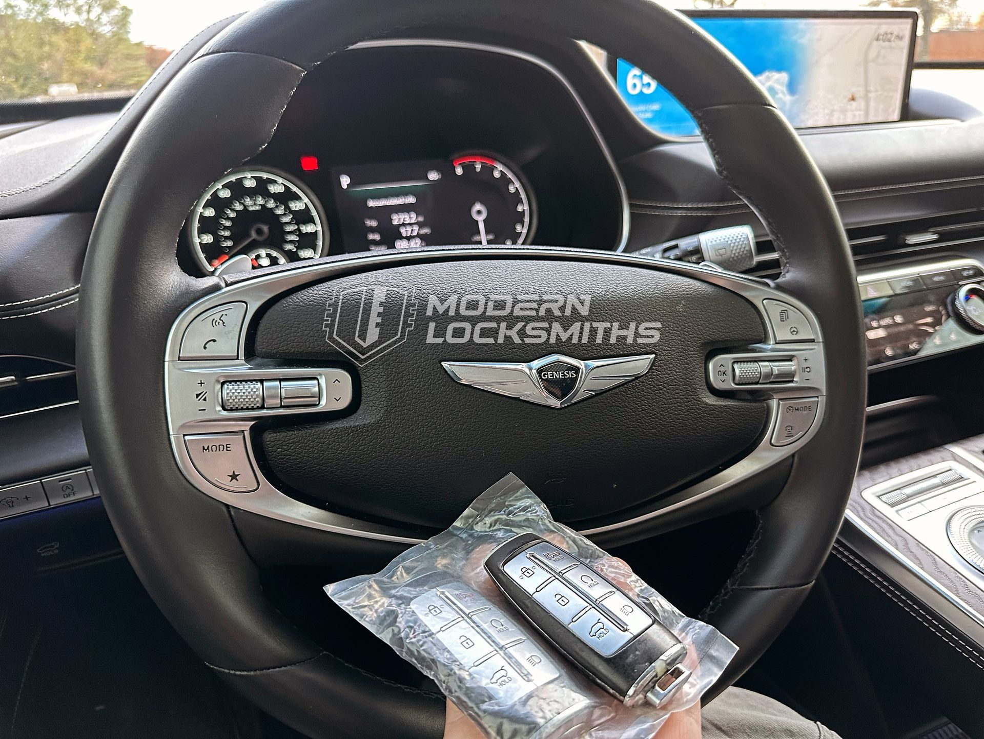 a hand holding a remote key fob for a vehicle