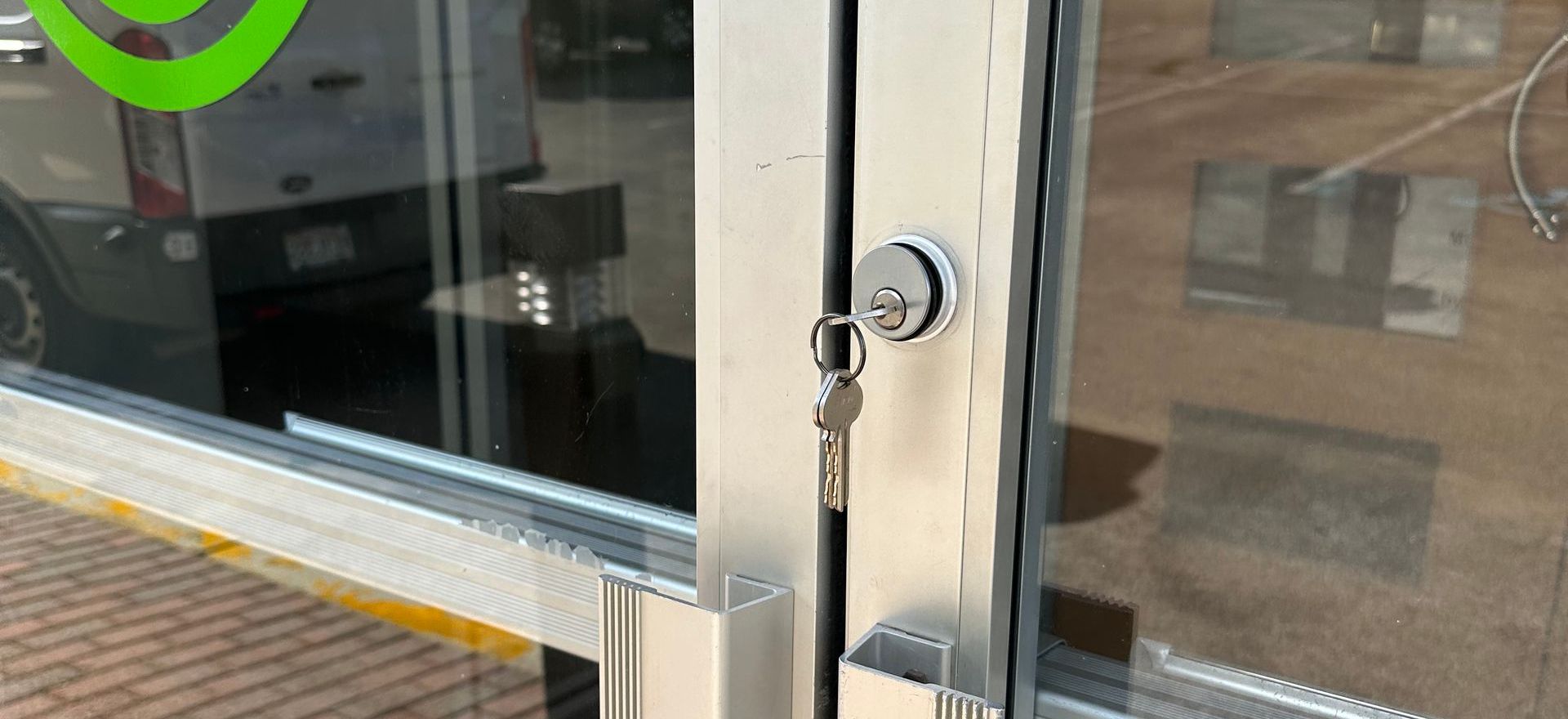 a storefront glass door with a lock and set of keys