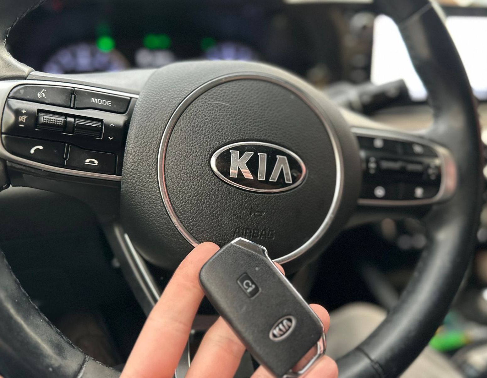 a hand holding a remote key fob for a vehicle