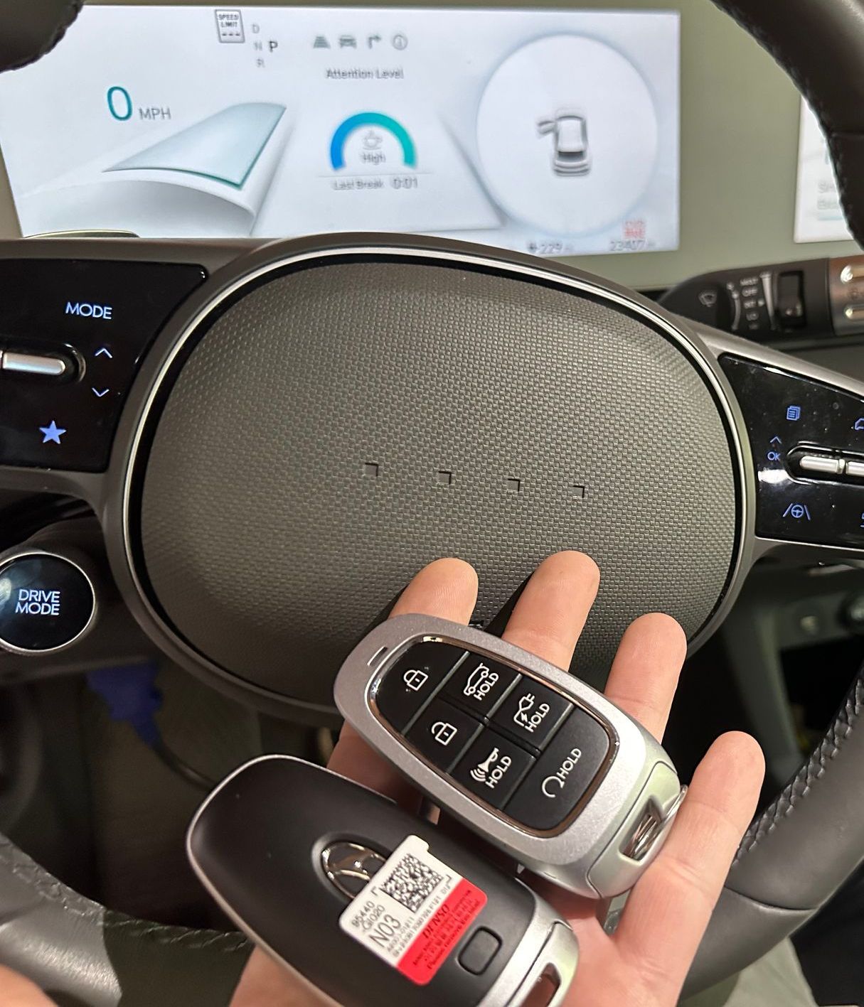 a hand holding a remote key fob for a vehicle