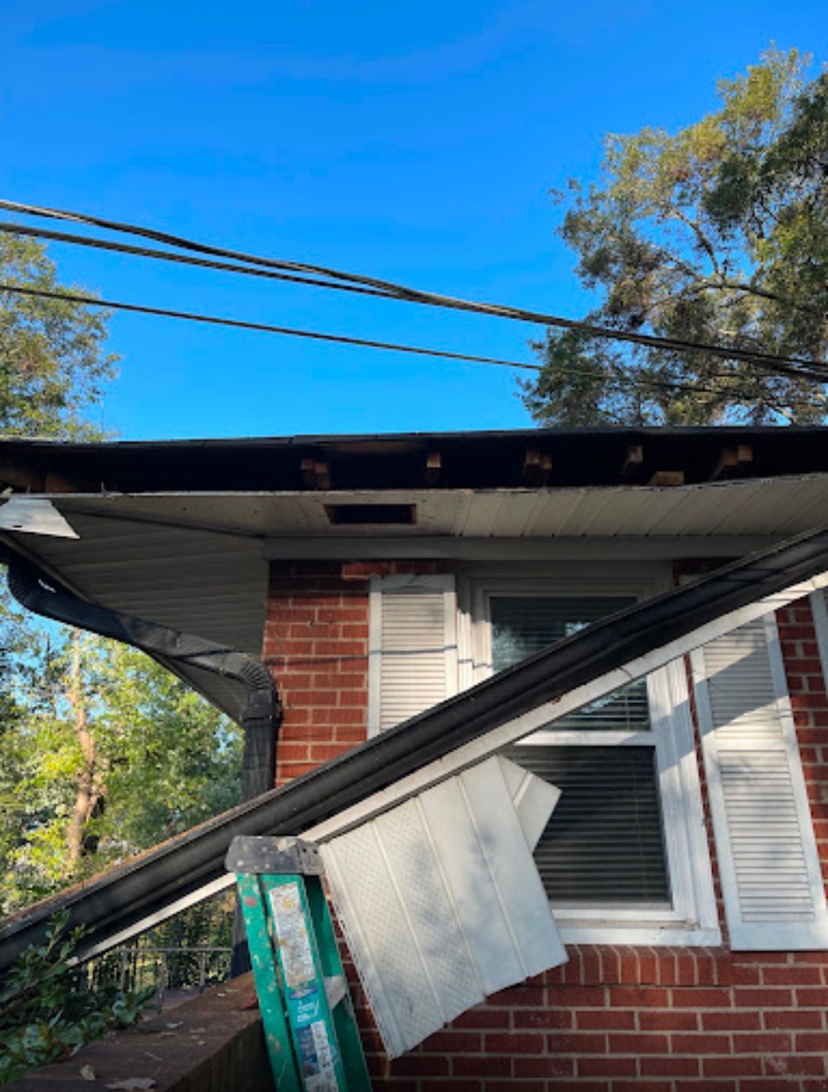 A blue tarp is covering the roof of a house.