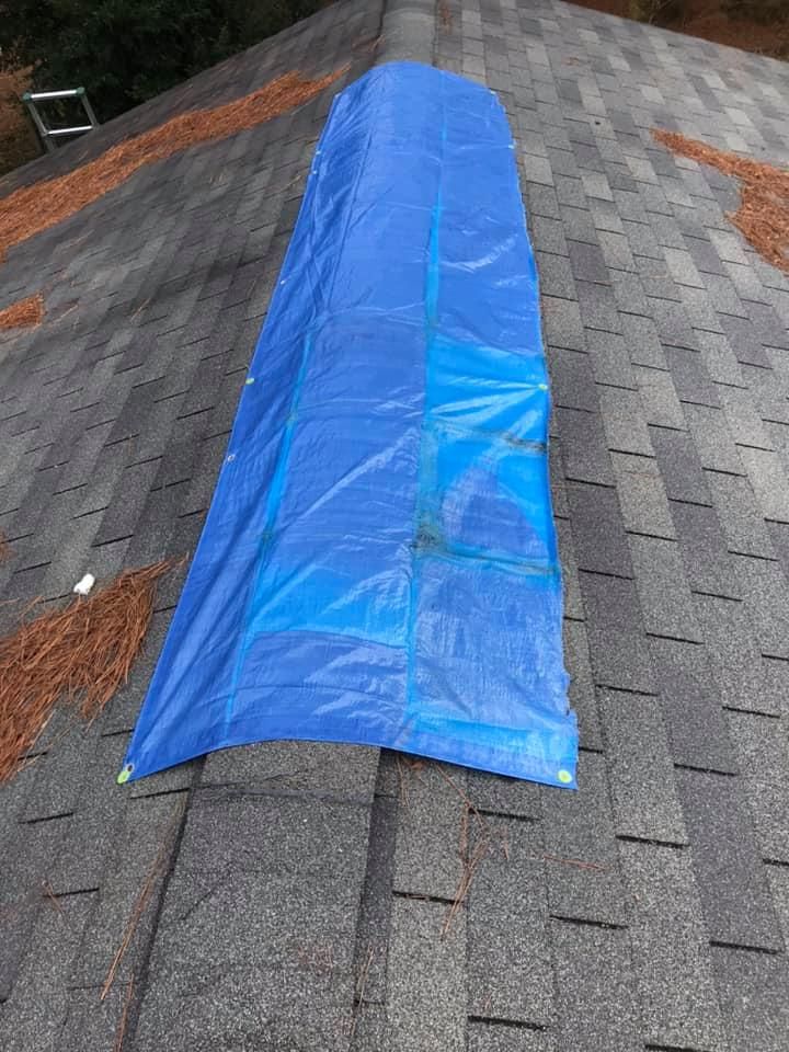 A blue tarp is sitting on top of a roof.