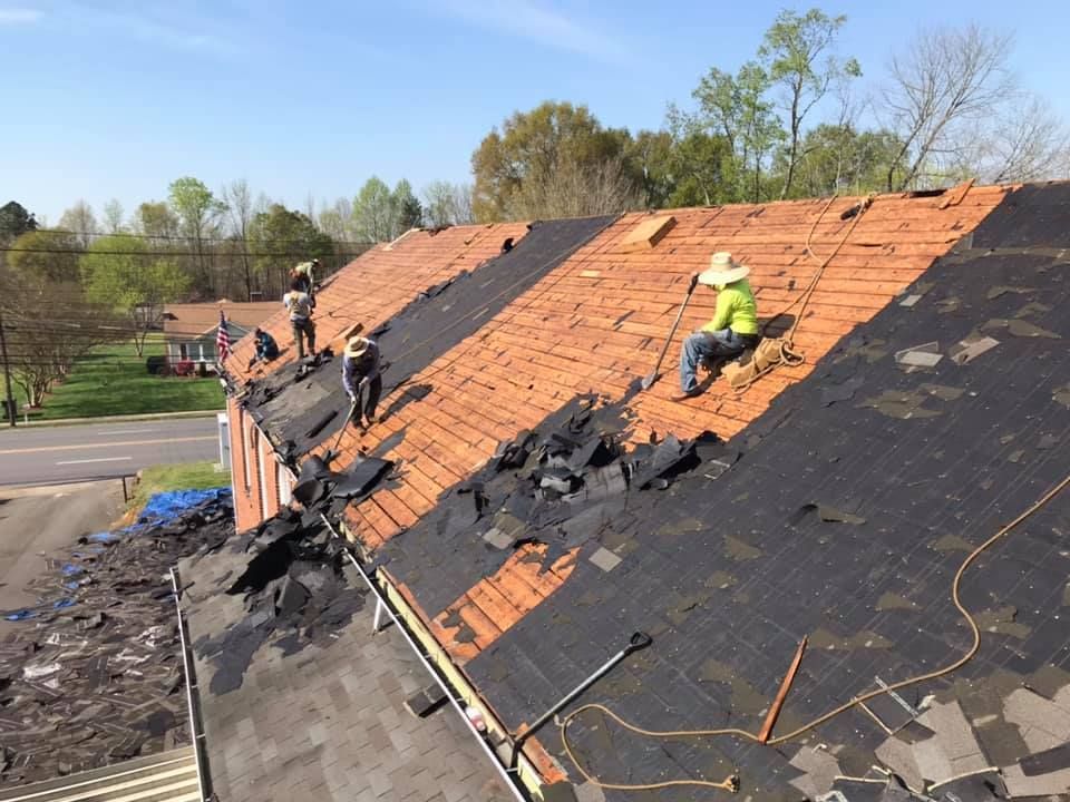 A group of people are working on the roof of a building.