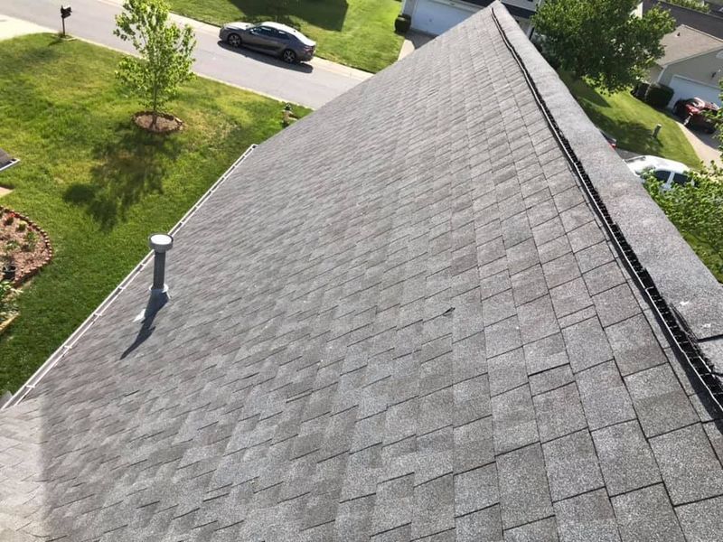An aerial view of a roof of a house in a residential area.