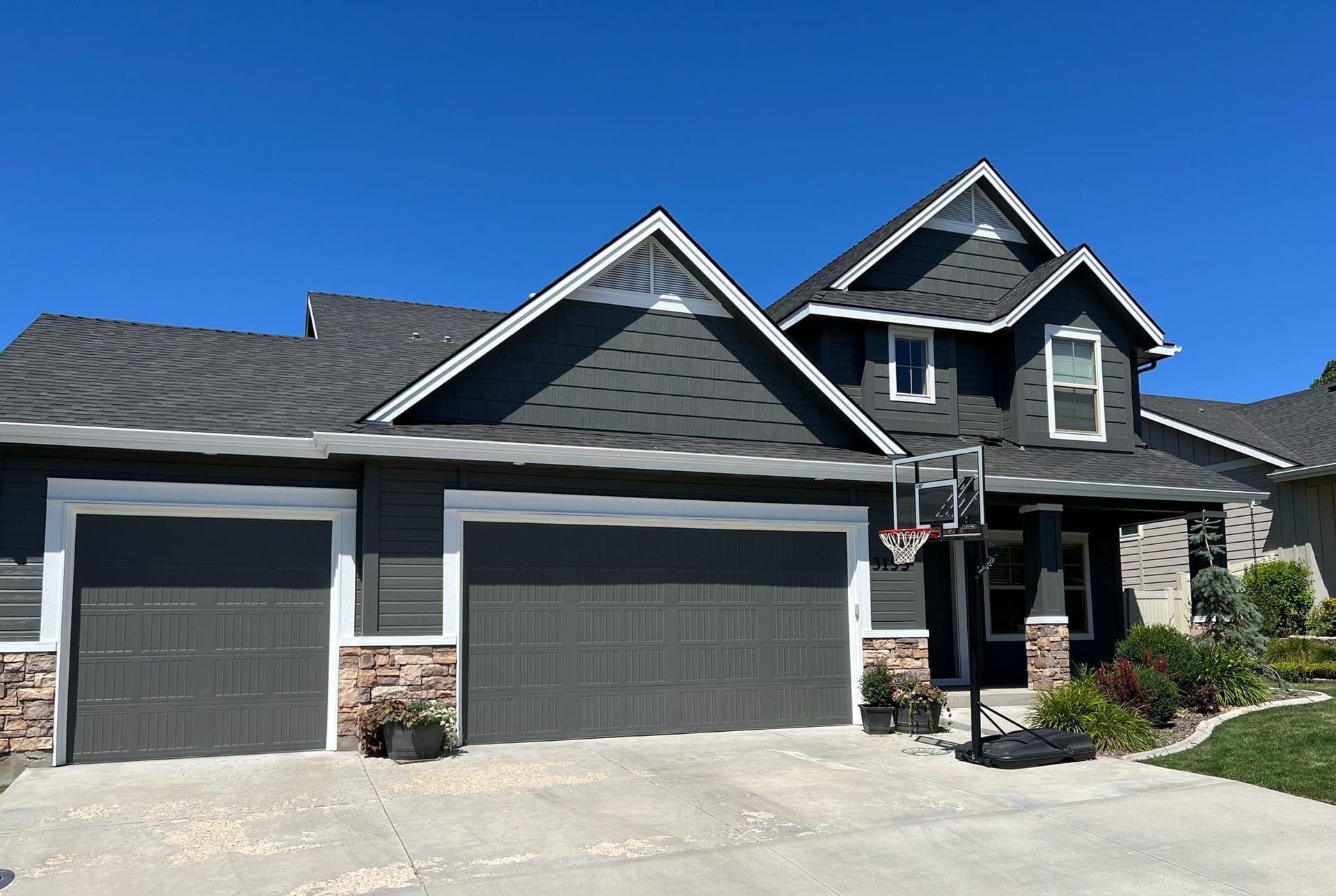 A large house with two garage doors and a driveway